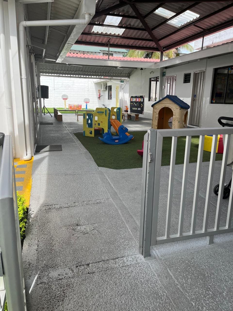 Acceso cubierto hacia el patio de juegos de Pequeño Nido